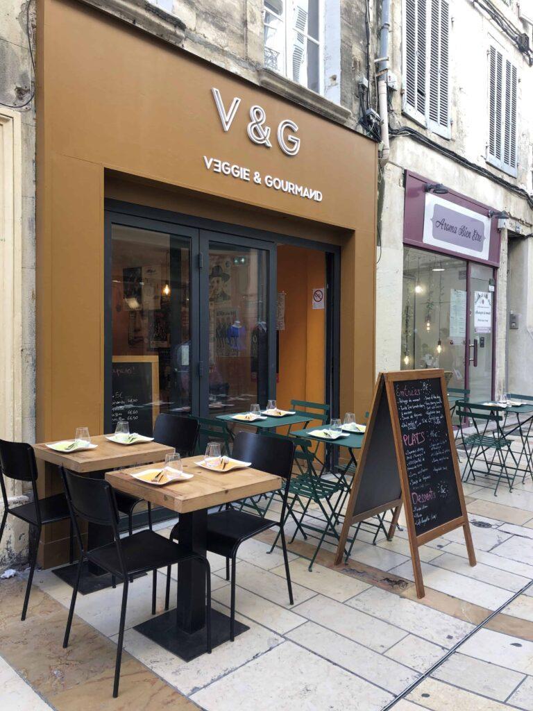 vegan and vegetarian restaurant v&g shop front in avignon featuring dining tables and menu chalk board